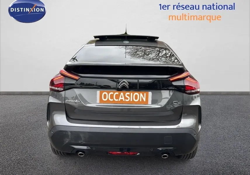 Vue arrière d'une Citroën C4 gris métallisé avec feux LED et double sortie d'échappement visible.