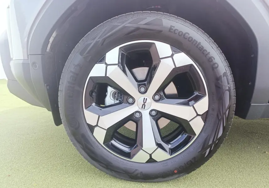 Gros plan sur la jante alliage diamantée 18 pouces noire et argent du Dacia Duster gris schiste.