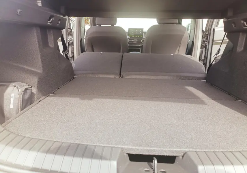 Vue intérieure du coffre du Dacia Duster 2026 avec banquette arrière rabattue, montrant l'espace de chargement étendu.