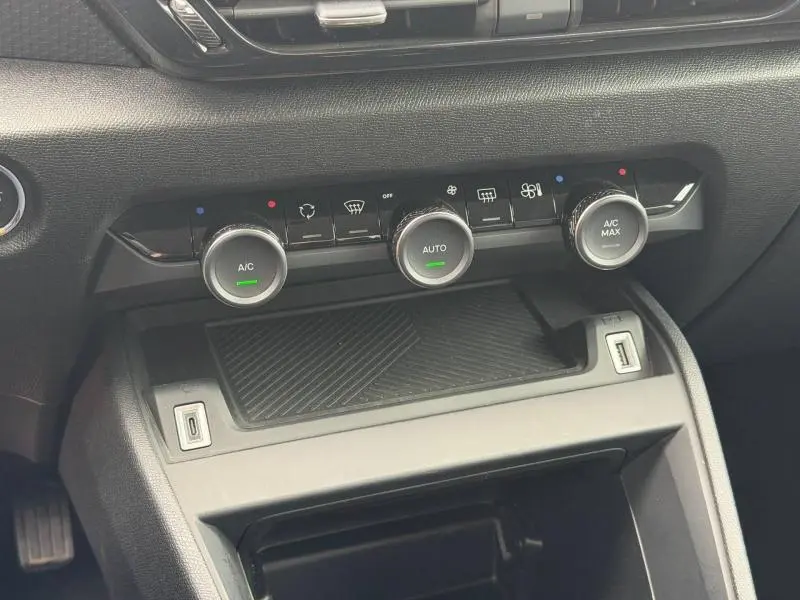 Gros plan sur la console centrale du Citroën C4 X 2024, montrant les commandes de climatisation avec boutons rotatifs et ports USB.