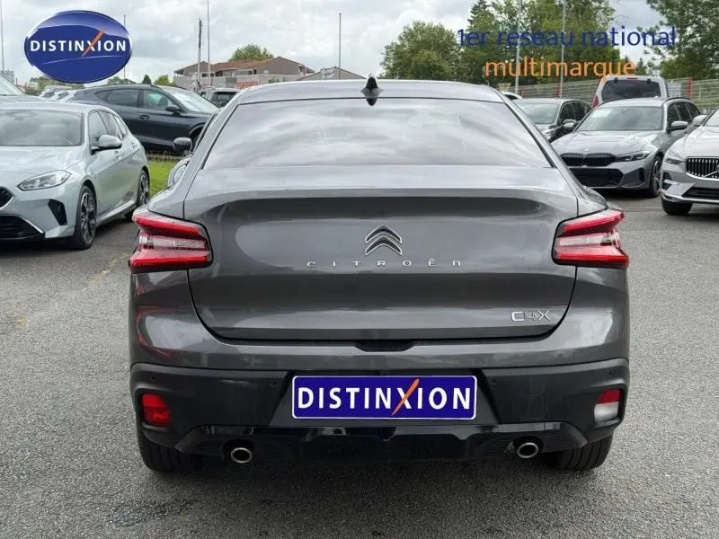 Vue arrière d'une Citroën C4 X 2024 en gris Platinium, avec feux LED distinctifs et double sortie d'échappement.