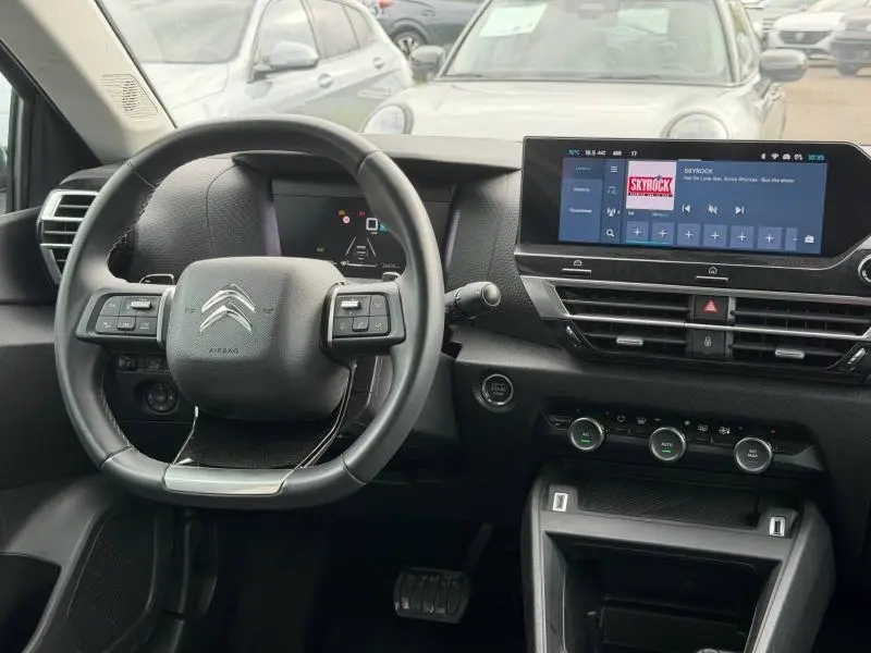 Vue intérieure centrée sur le volant et le tableau de bord du Citroën C4 X 2024, avec écran tactile et commandes intégrées.