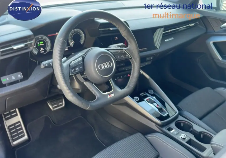 Vue intérieure côté conducteur de l'Audi A3 Sportback 2025, volant sport, tableau de bord numérique et sellerie tissu gris.