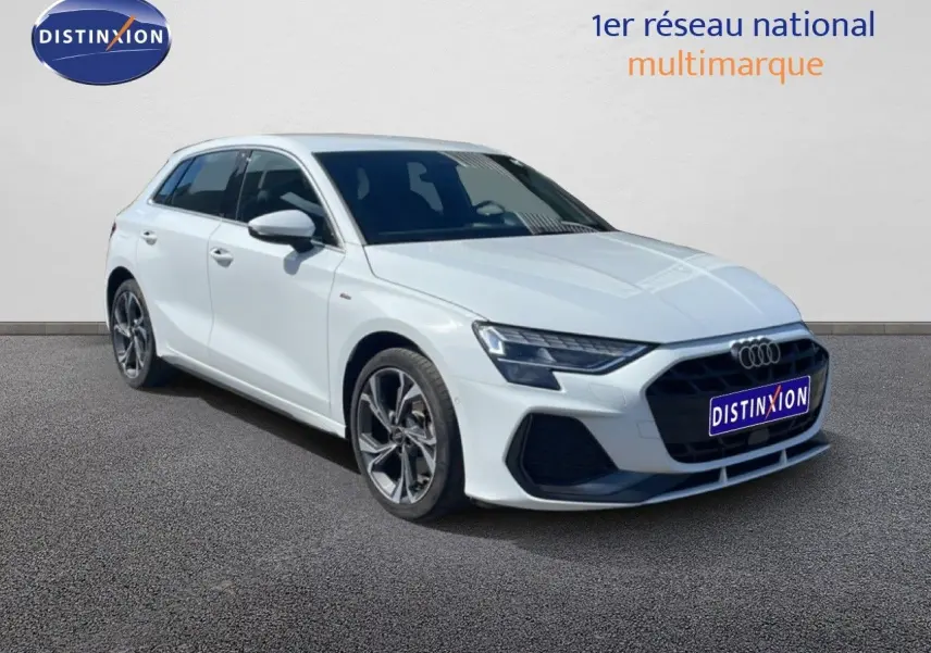 Audi A3 Sportback blanc Ibis en 3/4 avant droit, hybride rechargeable avec jantes alliage et calandre noire S-Line.