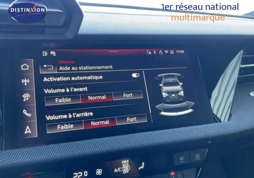 Écran tactile intérieur de l'Audi A3 Sportback blanc, affichant l'aide au stationnement et réglages audio.
