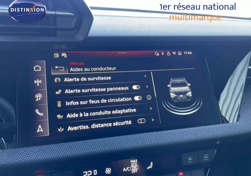 Vue rapprochée de l'écran tactile central de l'Audi A3 Sportback 2025 blanc, affichant les aides à la conduite.