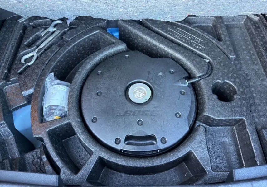 Vue rapprochée du coffre du Nissan Qashqai 2018 montrant le caisson Bose intégré au rangement noir en mousse.