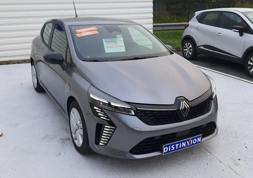 Renault Clio V TCE 90ch Evolution gris schiste vue 3/4 avant avec feux LED distinctifs sur parking extérieur.