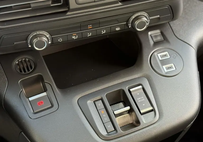 Vue rapprochée de la console centrale noire du Citroën Berlingo 2025 avec boîte auto et commandes climatisation.