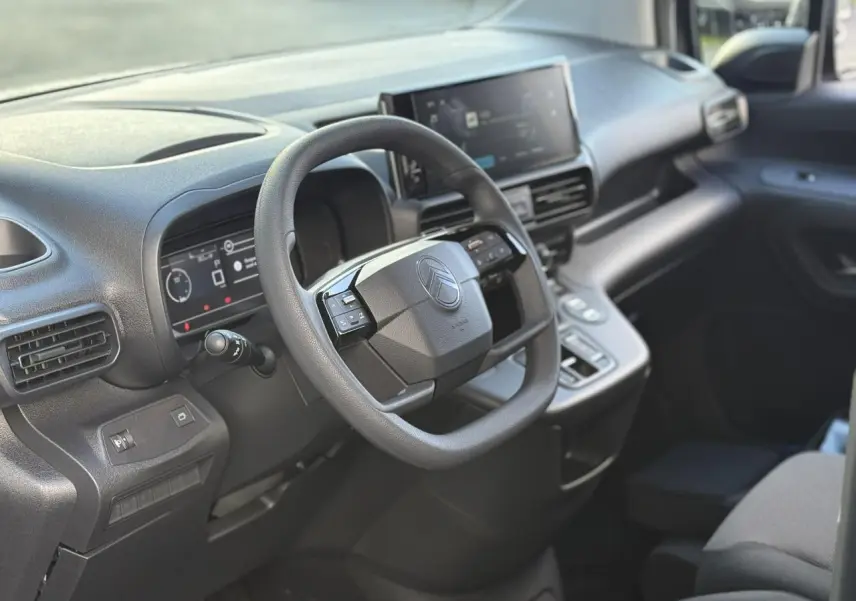 Intérieur du Citroën Berlingo 2025 vu côté conducteur, tableau de bord moderne avec écran tactile et volant multifonctions.