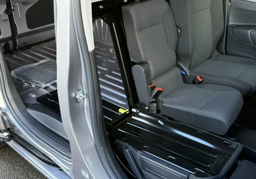 Vue intérieure côté droit du Citroën Berlingo gris Artense, montrant la banquette passager rabattue et l'espace de chargement.