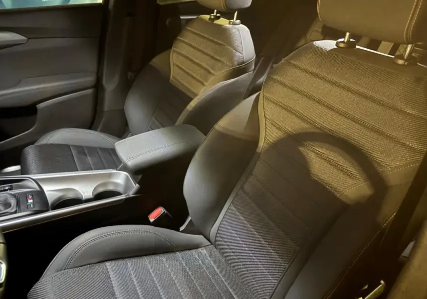 Vue intérieure rapprochée des sièges avant gris et de l'accoudoir central de l'Alfa Romeo Tonale 2023.