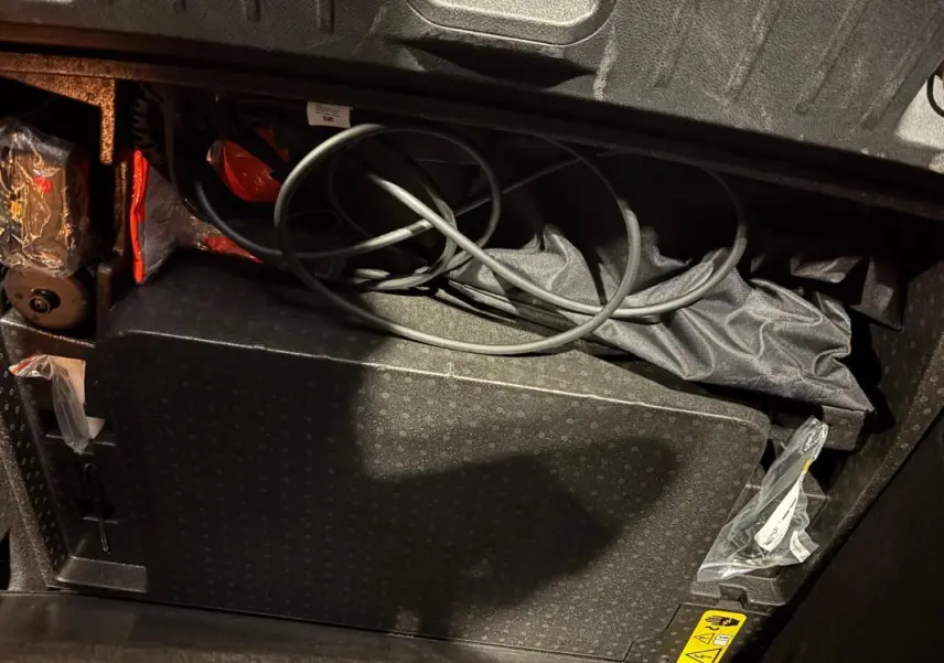 Vue rapprochée du coffre avec câbles de recharge et accessoires du SUV Alfa Romeo Tonale gris 2023.