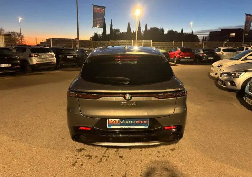 Vue arrière d'un Alfa Romeo Tonale gris 2023, avec feux arrière allongés et logo centré sous la lunette teintée.