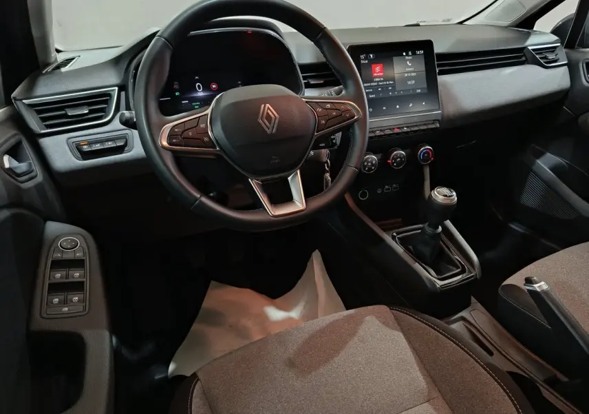 Vue intérieure avant droite de la Renault Clio noire 2025, volant cuir multifonctions et écran tactile central visible.