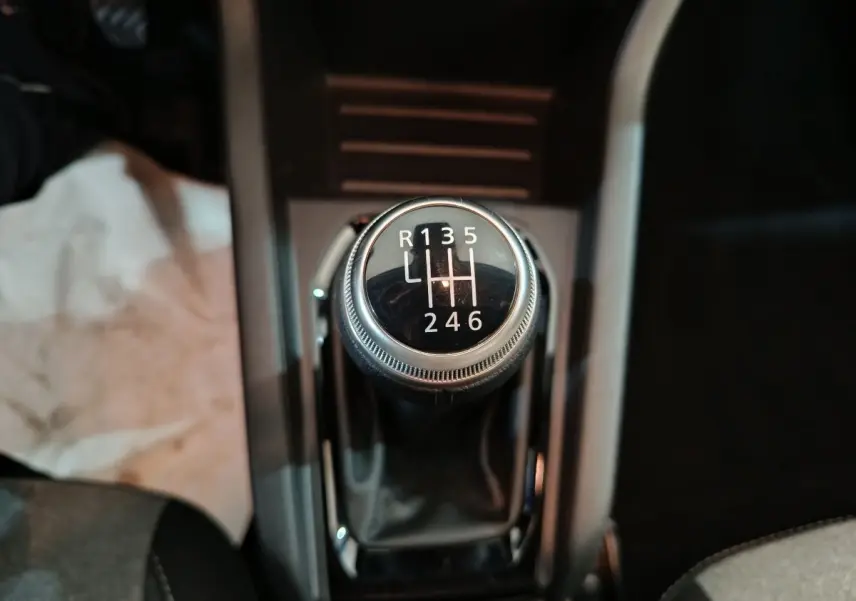 Gros plan sur le levier de vitesses manuel de la Renault Clio noire, affichant les six rapports et la marche arrière.