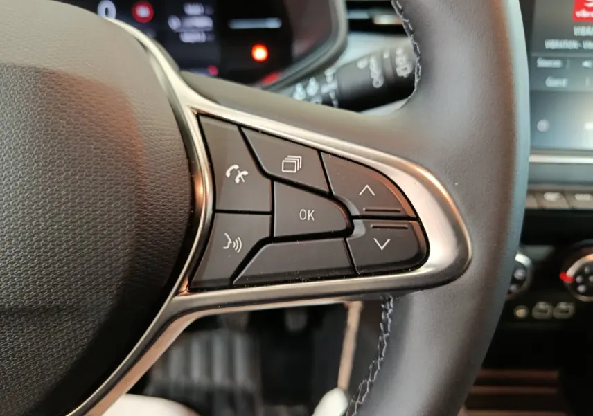 Gros plan sur les commandes multifonctions à droite du volant noir en cuir de la Renault Clio Evolution Blue dCi 100 2025.