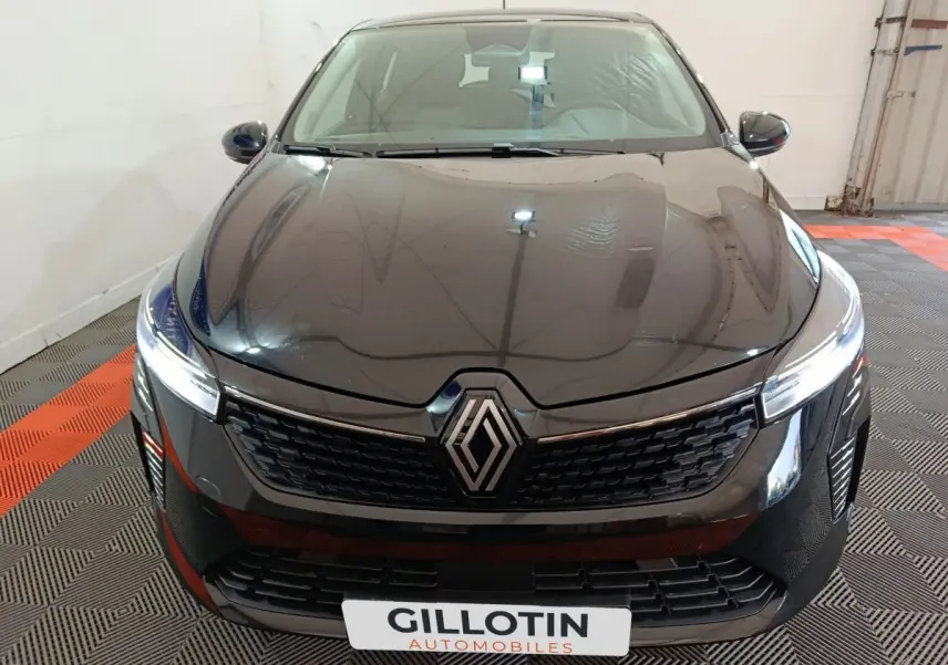 Vue avant d'une Renault Clio noire 2025 avec calandre moderne et logo Renault centré sur fond intérieur clair.