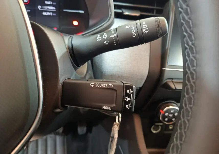 Gros plan sur les commandes au volant d’une Renault Clio noire 2025, avec affichage multifonctions et volant cuir.