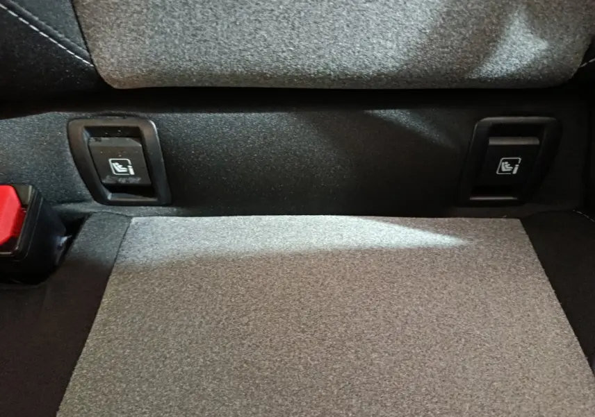 Détail des commandes de rabattement des sièges arrière dans le coffre de la Renault Clio Evolution Blue dCi 100 noire.