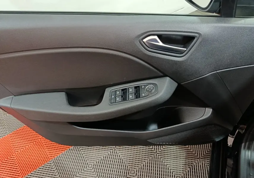 Vue rapprochée de la porte avant gauche noire de la Renault Clio 2025, avec commandes électriques des vitres et rétroviseurs.