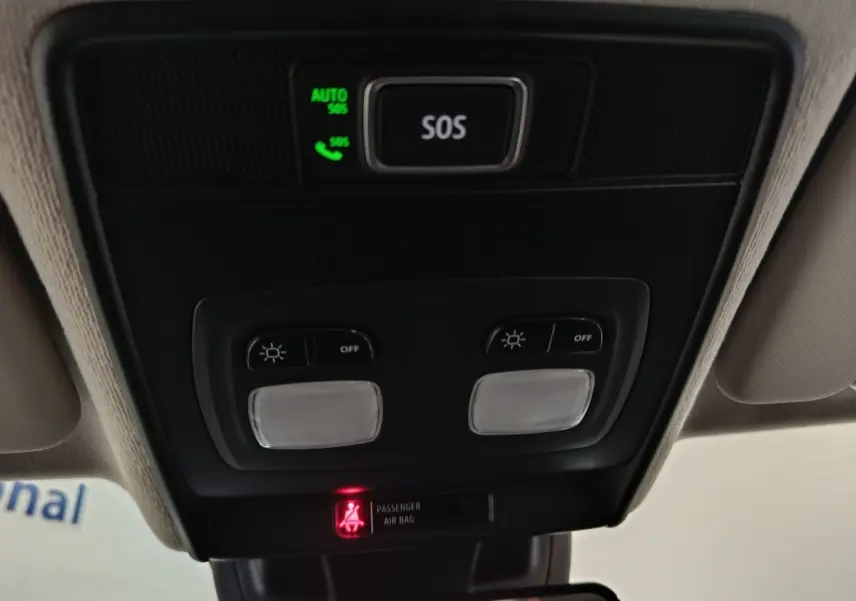 Vue intérieure en gros plan du plafonnier avec boutons d’éclairage et alerte airbag passager de la Renault Clio noire.