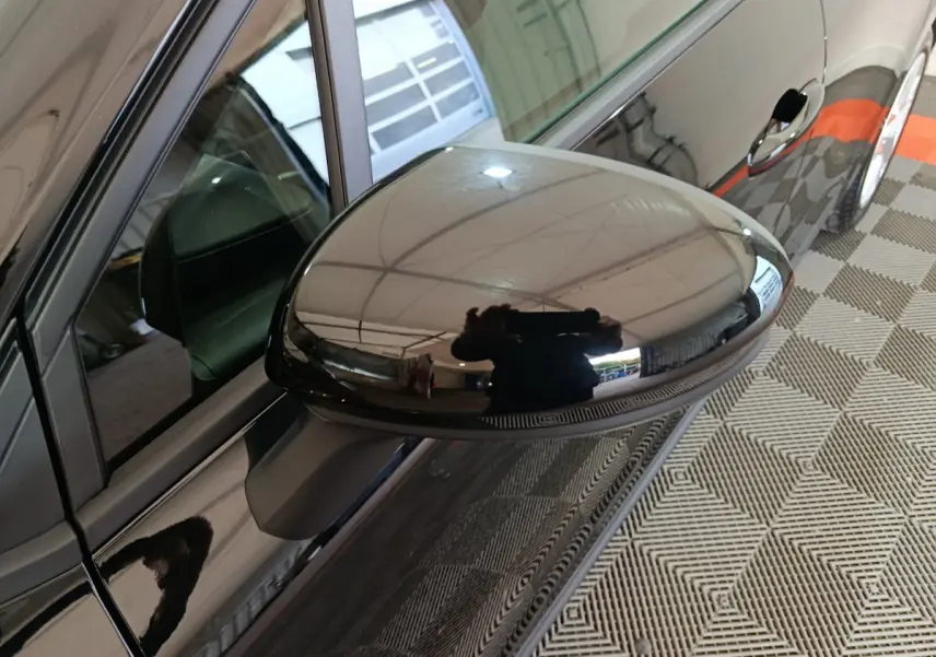 Rétroviseur côté conducteur noir brillant de la Renault Clio Evolution Blue dCi 100, vue rapprochée en intérieur.