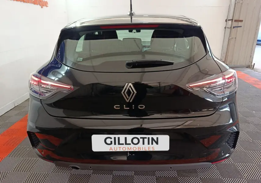 Vue arrière d'une Renault Clio noire 2025 avec feux LED allumés dans un garage intérieur.