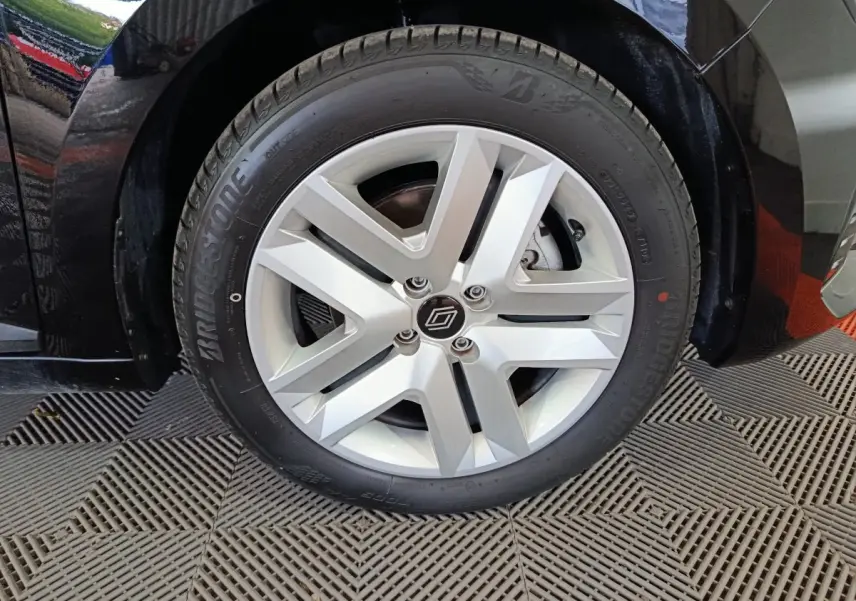 Gros plan sur la roue avant droite de la Renault Clio noire 2025 avec jante alliage et pneu Bridgestone.