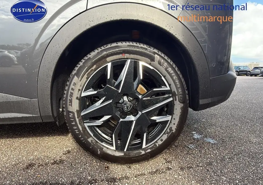 Gros plan sur la roue avant droite d’un Peugeot 3008 gris titane, jante alu noire et argentée au design moderne.