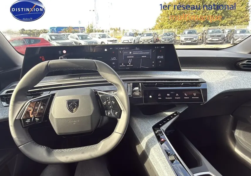 Vue intérieure du poste de conduite du Peugeot 3008 1.2 hybrid 145 allure e-dcs6 avec volant cuir et écran tactile panoramique.