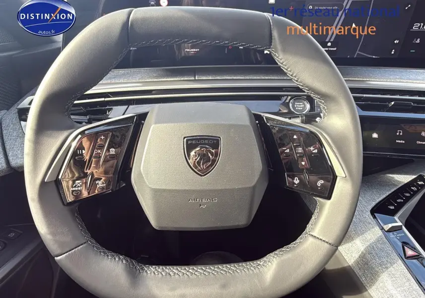 Vue rapprochée du volant cuir gris du Peugeot 3008 2024 avec commandes multifonctions et tableau de bord digital.