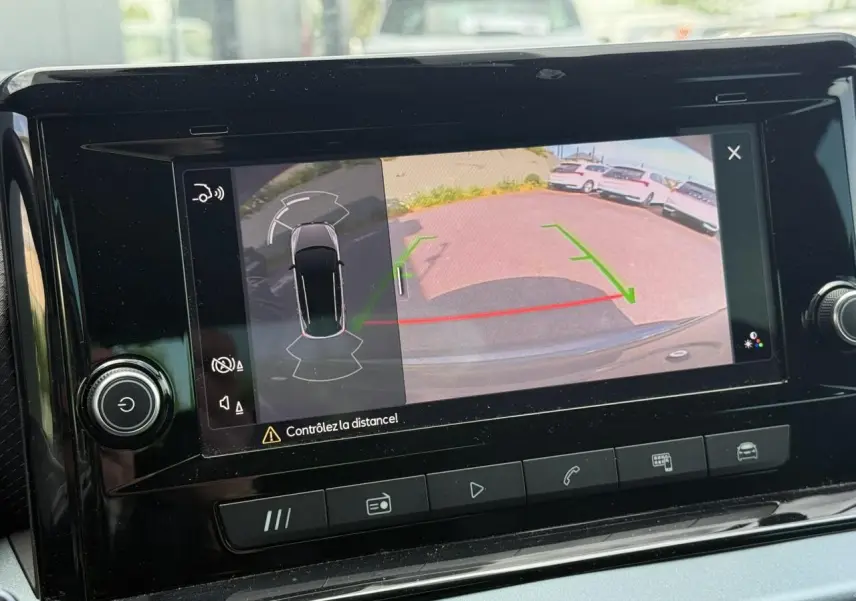 Affichage de la caméra de recul et des capteurs de stationnement sur l'écran central du tableau de bord d'un SEAT Arona gris Cliff.