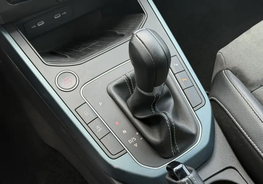 Vue rapprochée de la console centrale du SEAT Arona gris Cliff 2025, mettant en valeur le levier de vitesse automatique et les commandes environnantes.