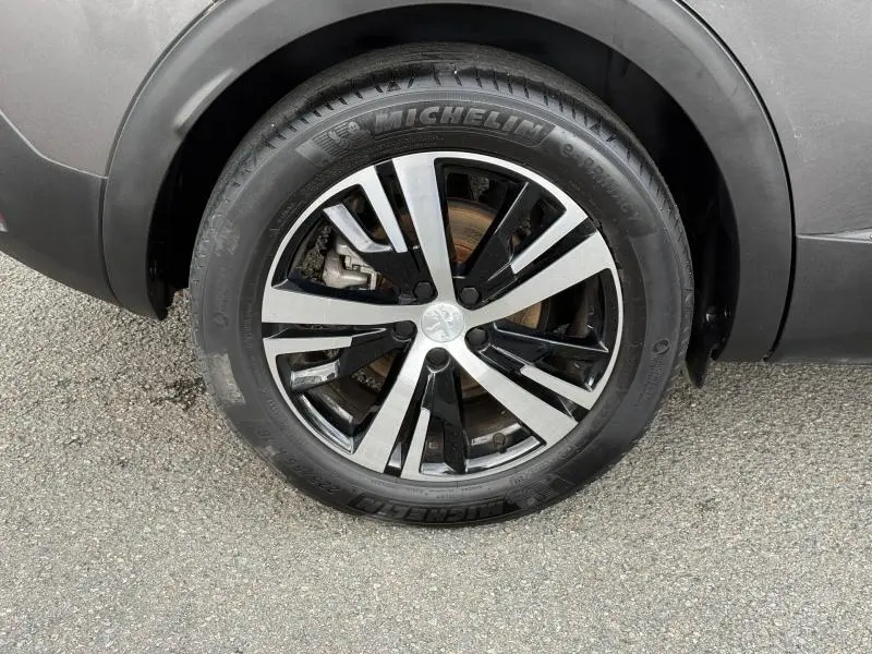 Gros plan sur la roue avant droite du Peugeot 3008 Gris Platinium 2024 avec jante alliage bicolore et pneu Michelin.