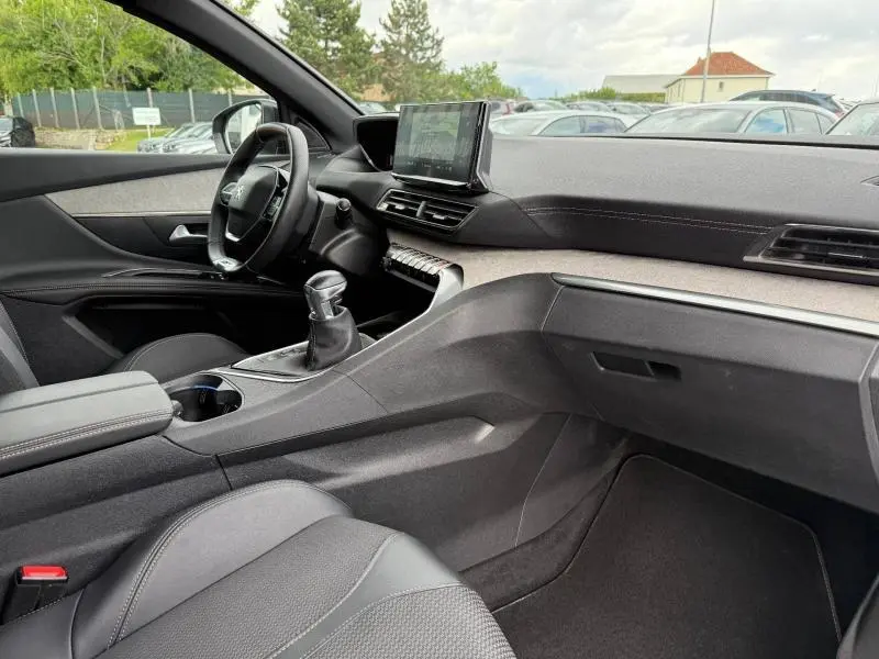 Vue intérieure côté conducteur du Peugeot 3008 2024 gris Platinium, avec tableau de bord moderne et levier de vitesse manuel.
