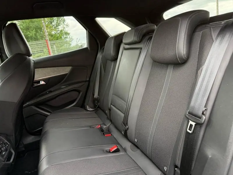 Vue intérieure côté droit des sièges arrière noirs du Peugeot 3008 2024 Gris Platinium, avec appuie-têtes et ceintures visibles.