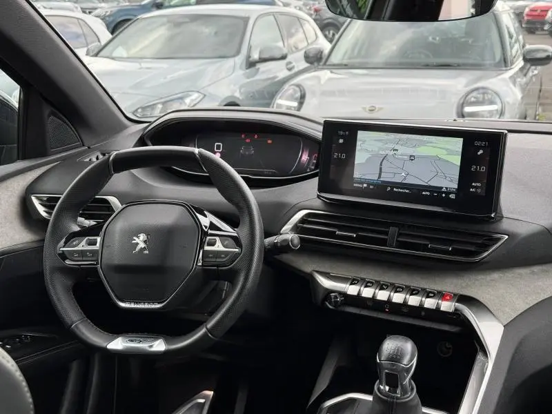 Vue intérieure du tableau de bord et volant du Peugeot 3008 2024, avec écran tactile et levier de vitesse manuel.