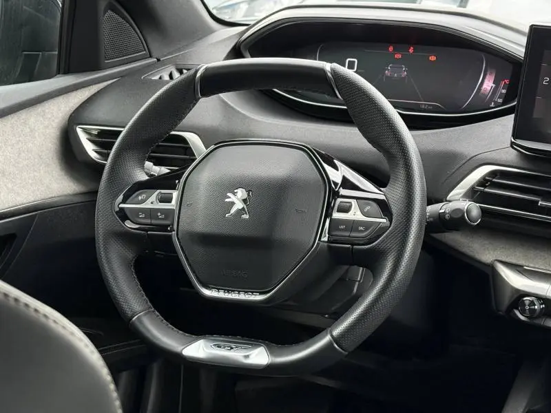 Vue rapprochée du volant cuir noir et du tableau de bord numérique du Peugeot 3008 Gris Platinium 2024.
