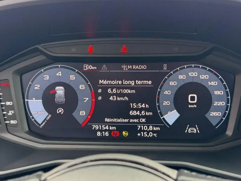Tableau de bord numérique de l'Audi A1 Sportback 25 TFSI 95ch Advanced affichant consommation et vitesse, vue de face.