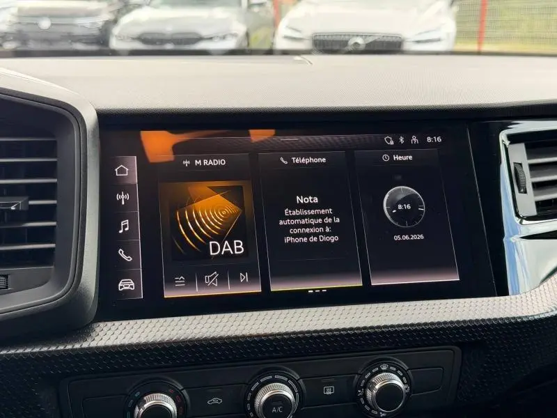 Écran tactile central de l'Audi A1 Sportback 25 TFSI 2023 affichant la radio DAB et la connexion Bluetooth, intérieur noir.