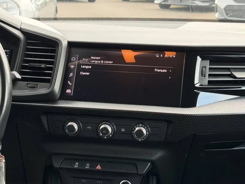 Vue intérieure du tableau de bord de l'Audi A1 Sportback 2023 avec écran tactile et commandes de climatisation.