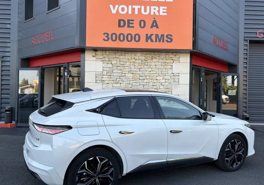 Vue côté droit arrière d'une DS4 blanche 2024 avec jantes noires et feux arrière LED au design distinctif.