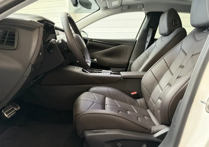 Vue intérieure côté conducteur du DS4 2024 blanc, sièges en cuir Nappa marron avec surpiqûres apparentes.