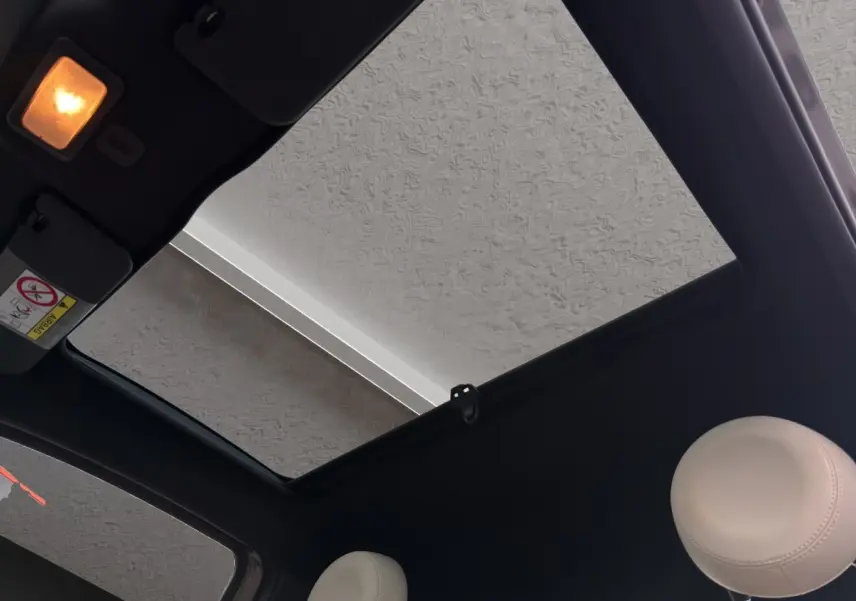 Vue intérieure du toit ouvrant panoramique et des appuie-têtes beige du Fiat 500 gris foncé 2020.