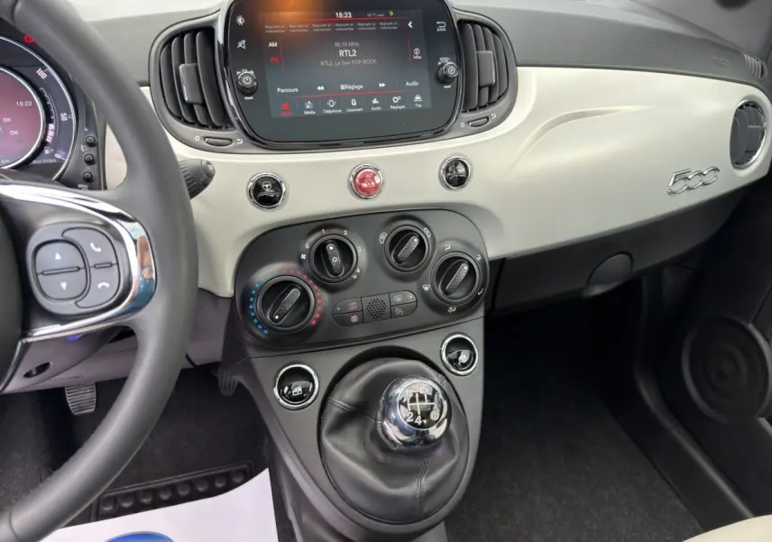 Vue intérieure de la Fiat 500 1.0 70ch BSG Star 2020, tableau de bord beige avec écran tactile et levier de vitesse manuel.