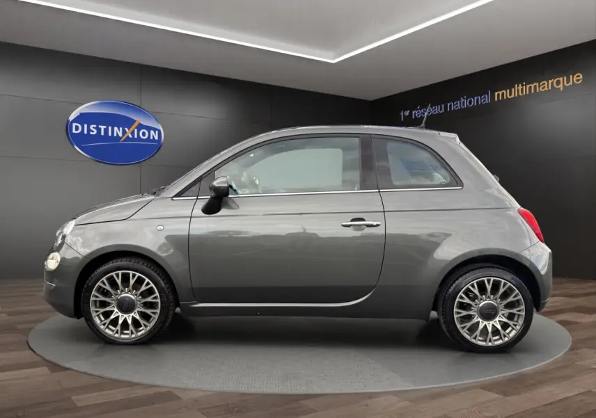 Profil droit d'une FIAT 500 gris foncé 2020 avec jantes alliage au design ajouré dans un showroom.