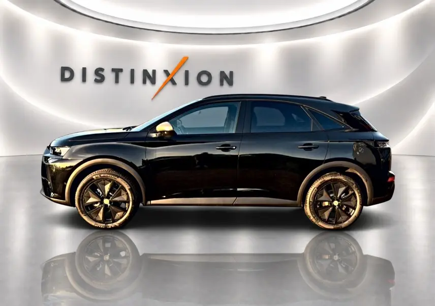 Profil droit du DS7 noir 2026 dans un showroom avec jantes noires et rétroviseurs couleur or.