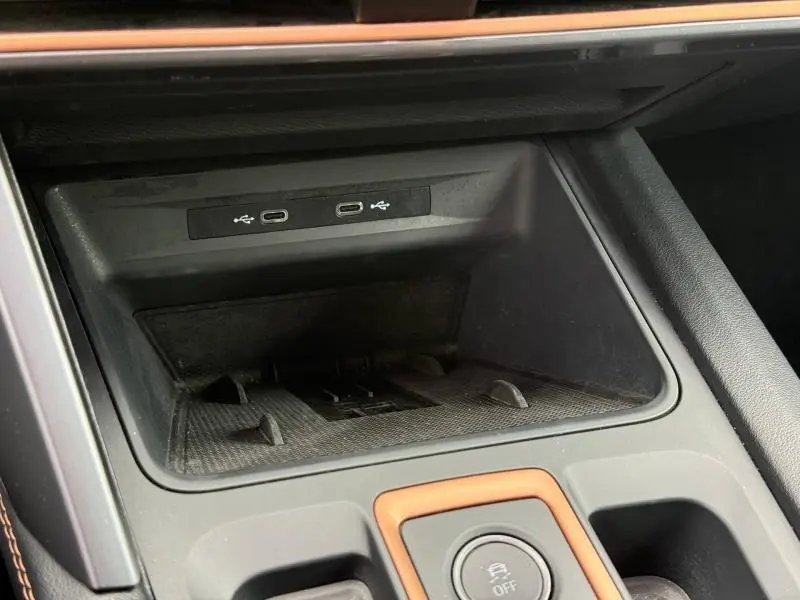 Vue rapprochée de la console centrale du CUPRA Formentor 2025, montrant les ports USB-C et les finitions noires avec surpiqûres orange.