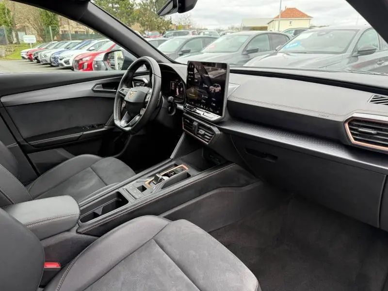 Intérieur de la CUPRA Formentor 1.5 eTSI Hybrid 2025 vu côté conducteur, avec écran tactile central et finitions noires élégantes.